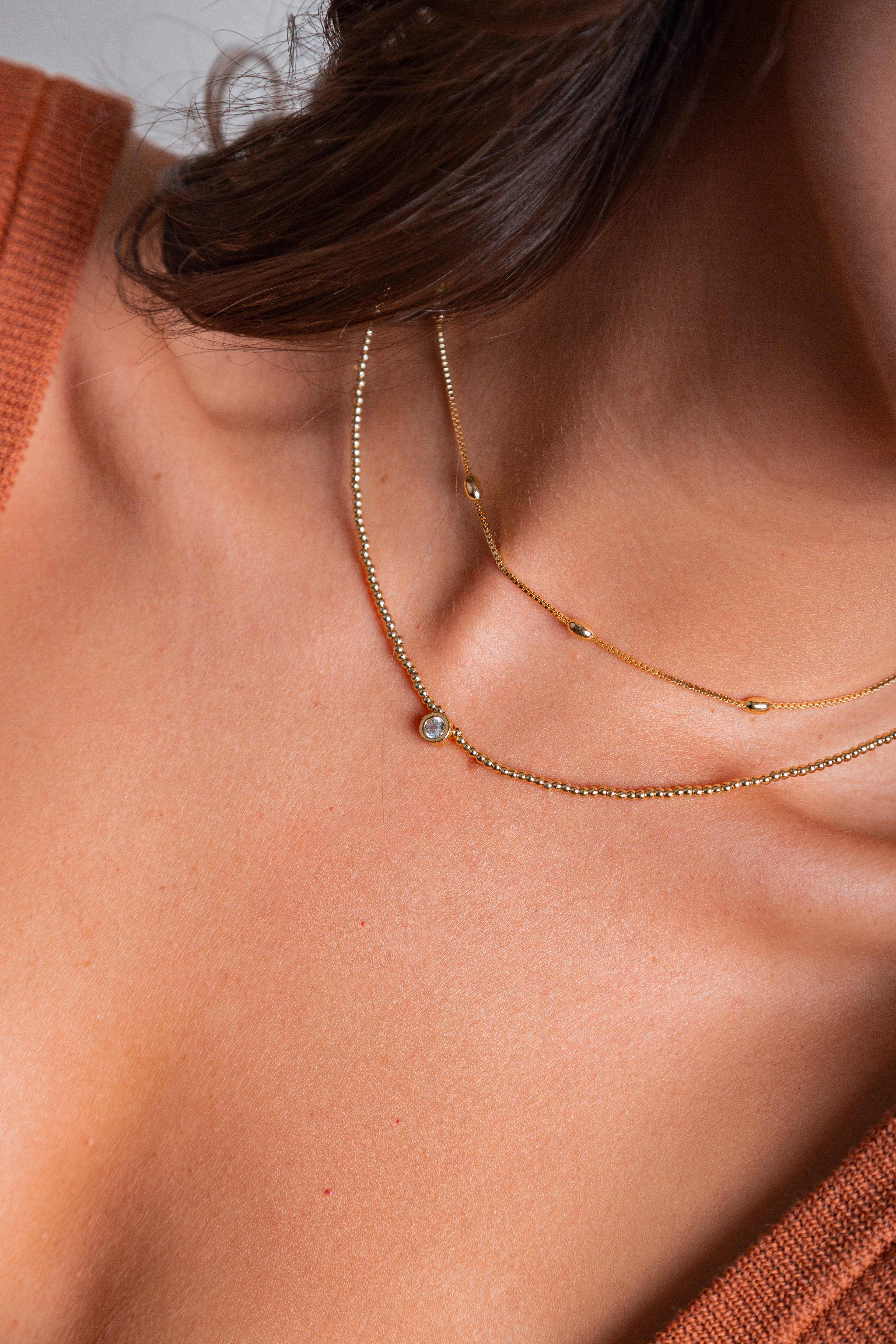 Collar Emilia con mostacillas doradas y punto de luz central – María Larraín