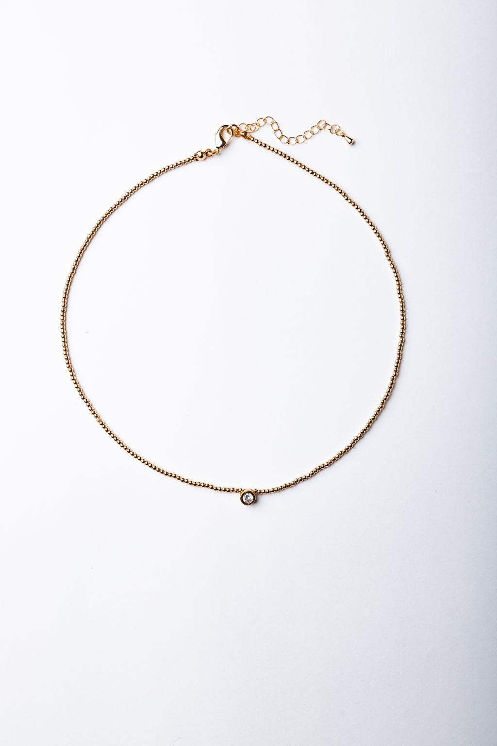 Collar Emilia con mostacillas doradas y punto de luz central – María Larraín