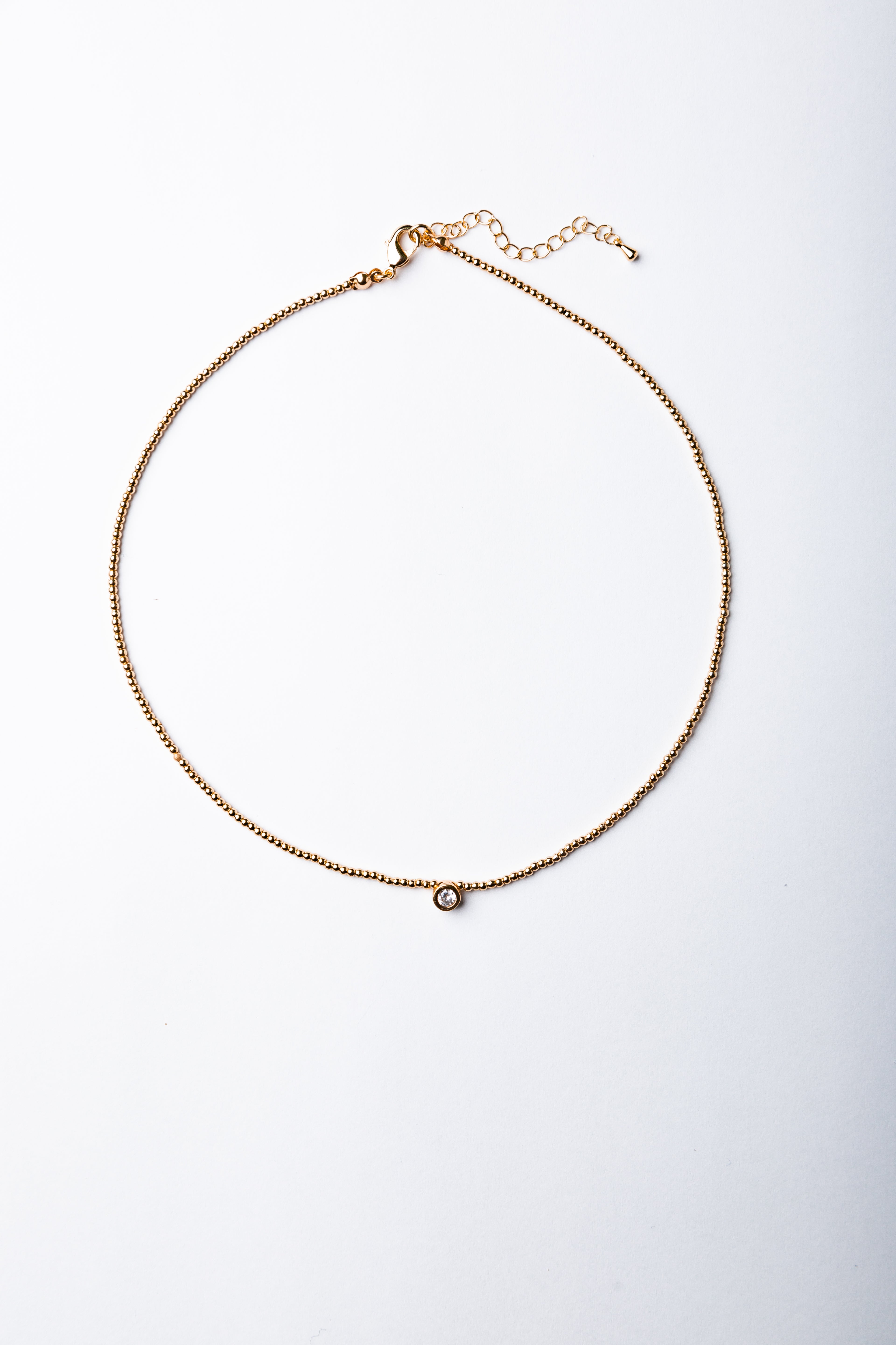 Collar Emilia con mostacillas doradas y punto de luz central – María Larraín